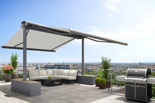 Markisen-Ständersystem markilux syncra mit weißem Markisentuch und grauem Gestell, befestigt mit Beschwerungskästen auf einer Dachterrasse mit Blick über die Stadt.